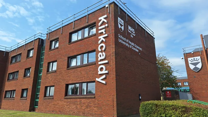 New signage at Kirkcaldy campus. The sign spells outs "Kirkcaldy" in vertical letters going down the side of a red-brick accomodation block