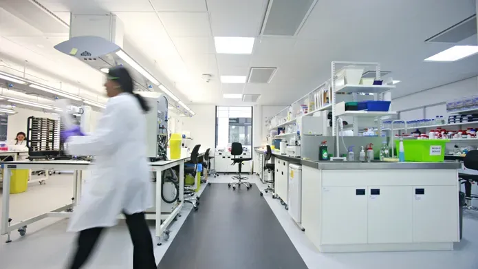 inside a science lab, blurred image of person walking across 