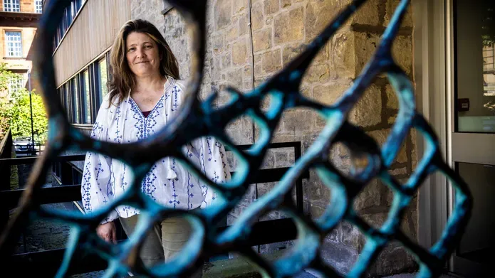 Georgia Crook in the background with a metal sculpture framing a circle around her face