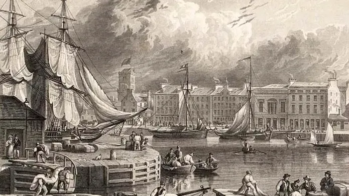 Imagine of a Dundee harbour with ships and part of Dundee city in the background. 