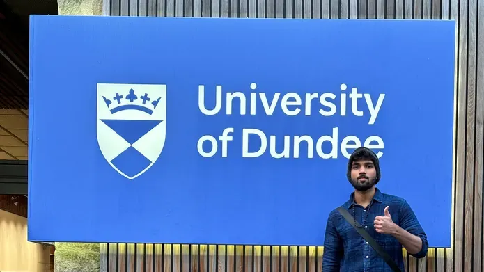 Aswin Poornachandran outside the Tower Building in front of the University of Dundee signage