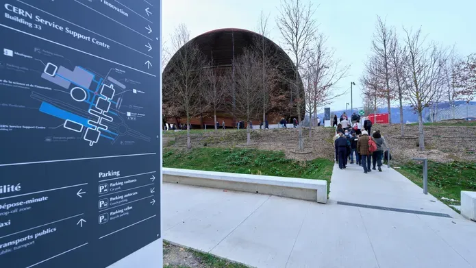 The exterior of the CERN complex in Geneva, Switzerland, showing a tall, wood-clad spherical building