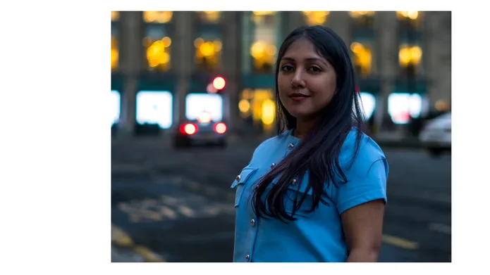Sherin standing on the side of a road with an office building in the background