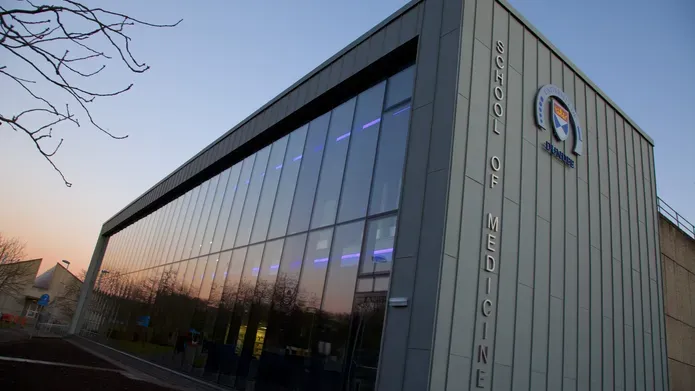 The exterior of the School of Medicine library at sunset