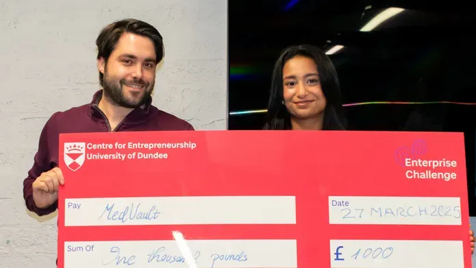 Chris Smyth standing with Amna Waqas of MedVault, winner of the Enterprise Challenge final, holds up a large check
