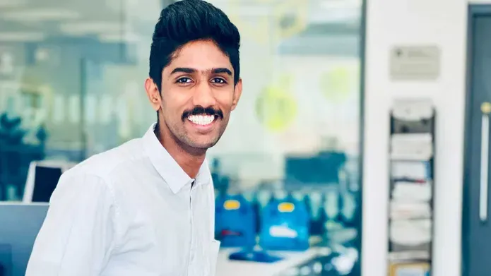 Gokul Raghunathan wearing a white shirt and smiling.