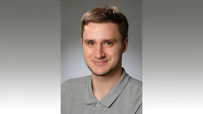 A head and shoulders photo of a man smiling