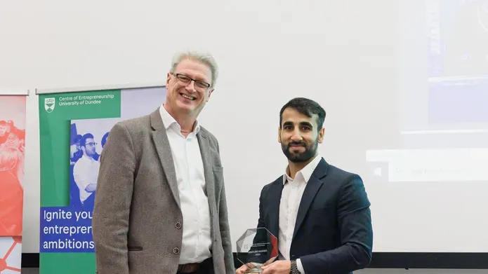 Man presenting an award to a student 