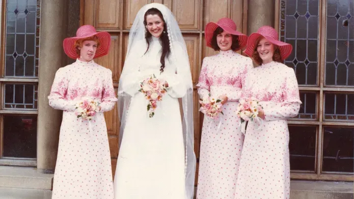 1974 wedding photo of Anne Kendall standing on the front steps of a building with her bridesmaids