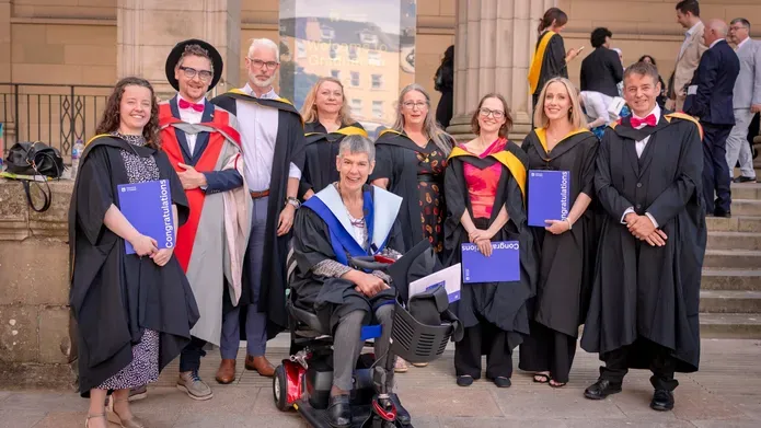 Graduates posing outside the Caird Hall