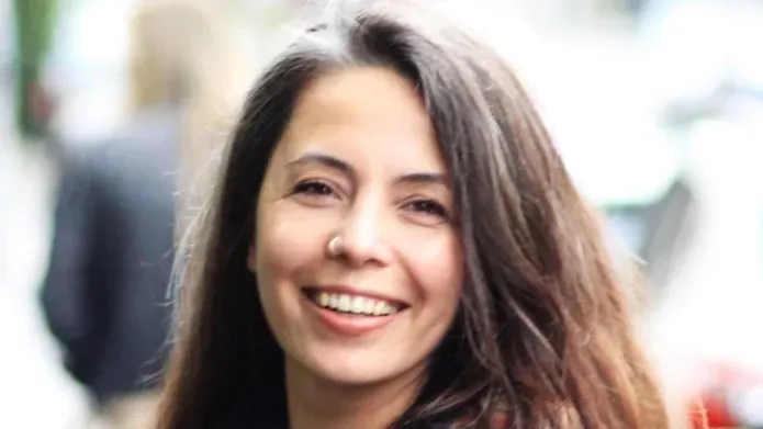 A person stood in a street smiling