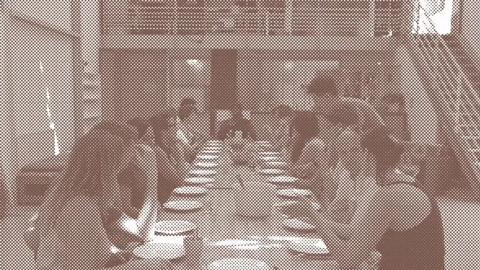 A group of people gathered eating around a long table