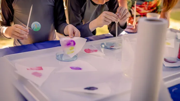 Young children taking part in a science experiment with coloured liquids