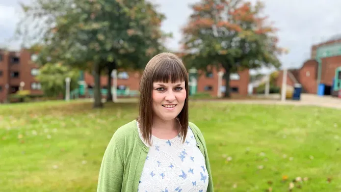 image or woman with shoulder length dark hair in a grassy area