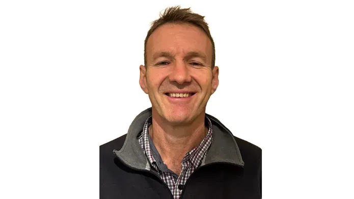 A head and shoulders photo of a man smiling