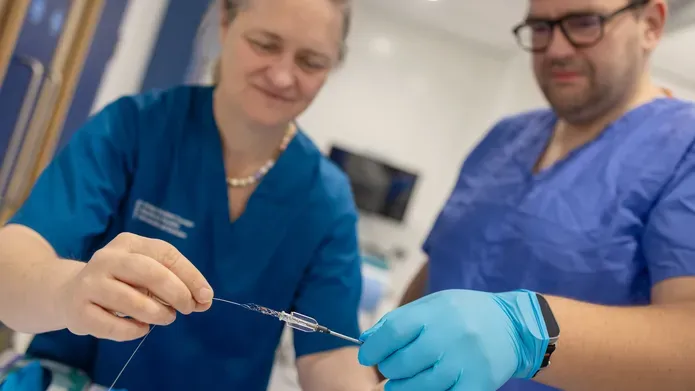 close up shot of two medical workers holding a piece of medical equipment 
