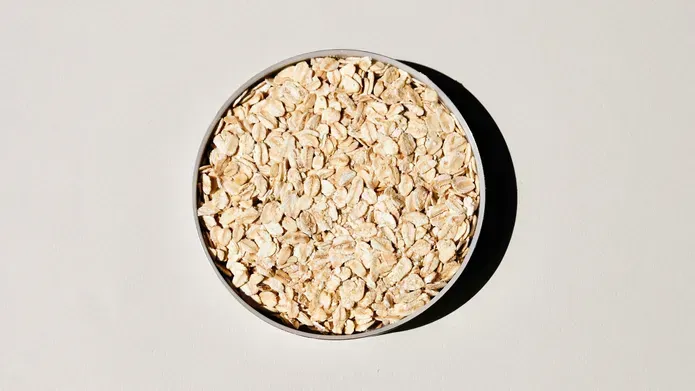A bowl of porridge oats in white bowl on a white counter