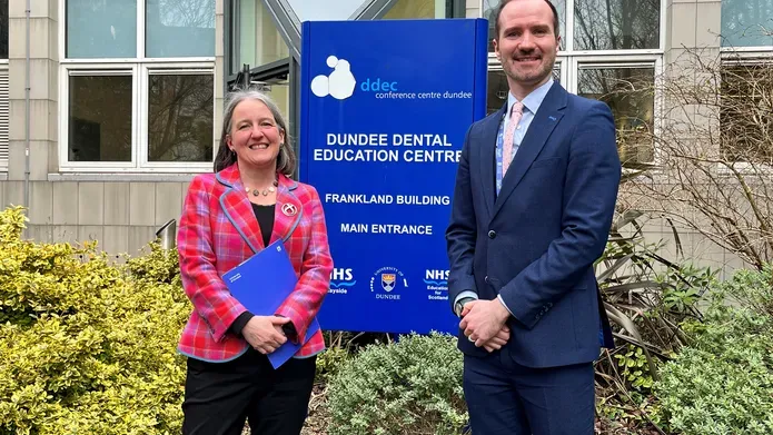 Maree Todd and Niall McGoldrick standing side-by-side at the entrance to the Dundee Dental Education Centre