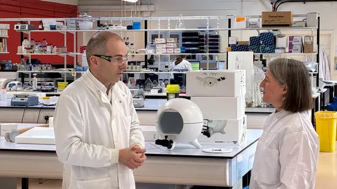 Maree Todd MSP hearts about drugs testing work at the University of Dundee, with a forensic science laboratory in the background