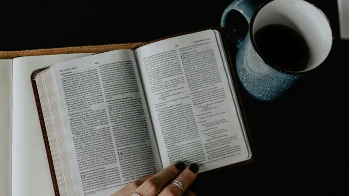 An overhead image of a book and cup of coffee