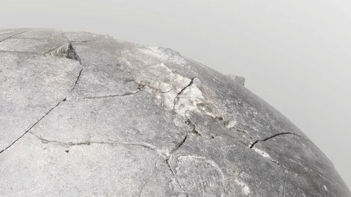A section of a grey concrete looking sphere, against a pale grey background.
