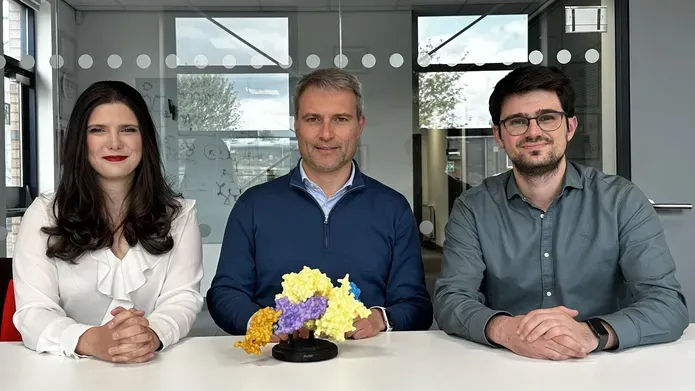 Co-corresponding author Alessio Ciulli (centre) and co-first authors Valentina Spiteri (left) and Alejandro Correa-Sáez (right) sat in front of a coloured model of the cryo-EM structure of the complex between the SMARCA2 bromodomain ( shown in orange), DCAF16 (purple), DDB1(ΔBPB) (yellow), and DDA1 (blue), glued by the degrader compound (grey)