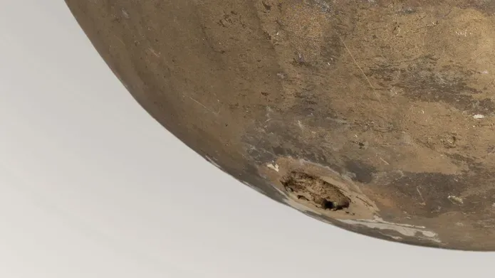 A section of a rounded bronze/stone sculpture.