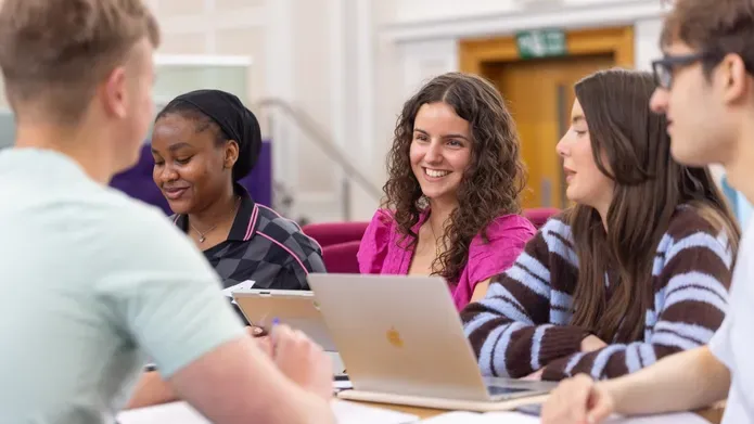 students smiling around a desk