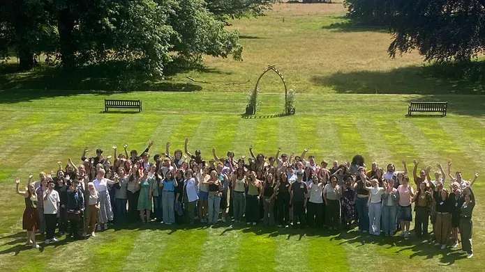 A large group of people stood together on a lawn