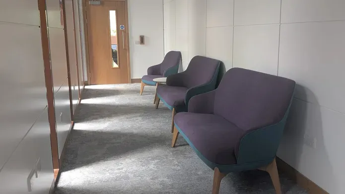A row of sofa's and a chair in a hallway