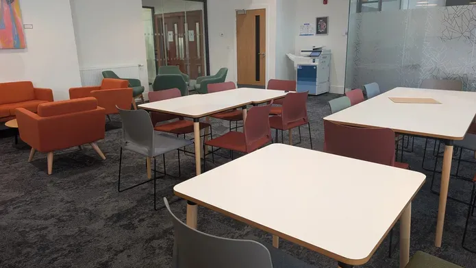 A study area in OMS with single chairs, tables with several chairs and arm chairs