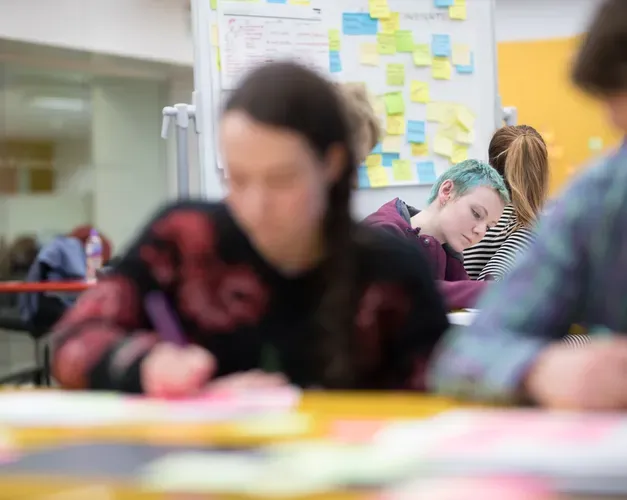 Students working on paper with lots of post it notes