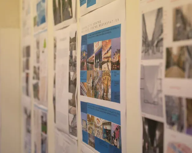 a wall showing printed sheets of urban planning designs