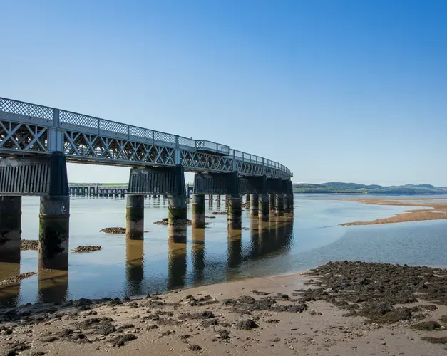 Tay Bridge on a sunny day with sandy shore nearby