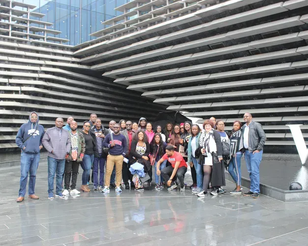 a group of people standing in front of the V&A museum