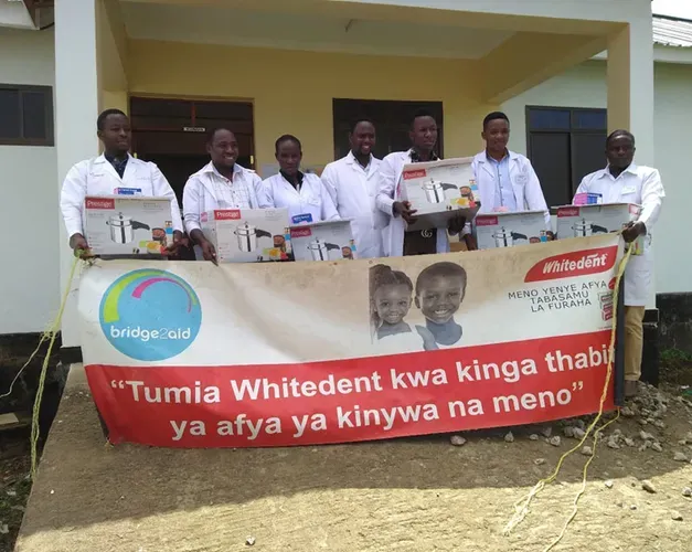 a group standing holding a sign for bridge 2 aid