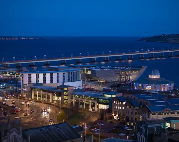 the waterfront at Dundee showing the city at night, and the tay road bridge