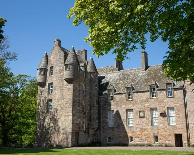 A photograph of Kellie Castle with trees in the foreground