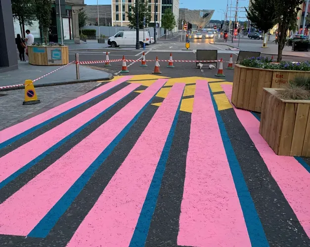 a street that has been painted with pink and blue stripes