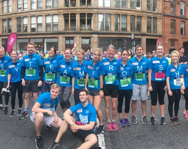 people in blue t-shirts all standing together before a race
