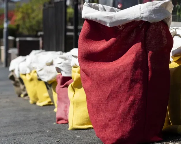 A line of cloth sacks in bright yellow and red all set in a row on a street