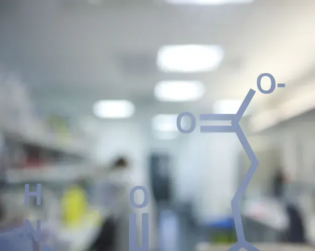 molecule painted on glass wall in front of a blurred out lab