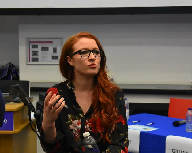 Presenter at the Venture 2018 competition sitting in a conference room giving a speech
