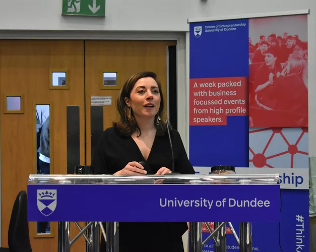 A person standing at a podium for the Venture 2019 finals competition presented by Centre for Entreprenuership