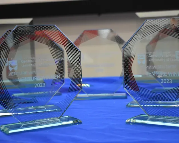Glass trophies for Venture competition winners sitting on a table with a blue table cloth