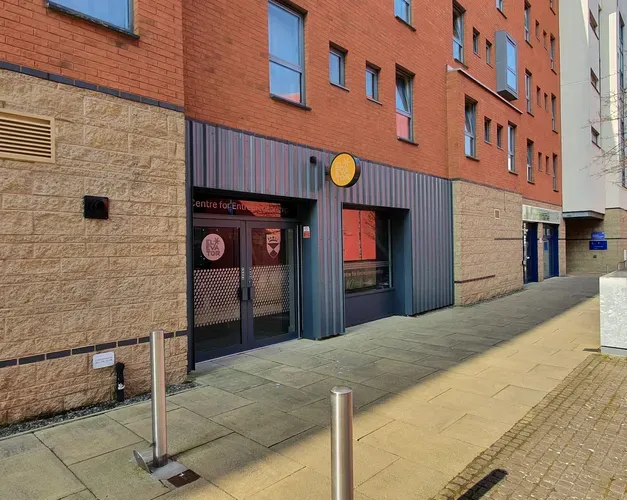 Path going along side a building, the entrance to the Centre for Entrepreneurship.
