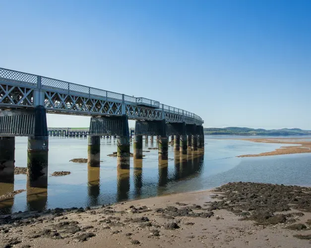 rail bridge stretching out across the river on a sunny day