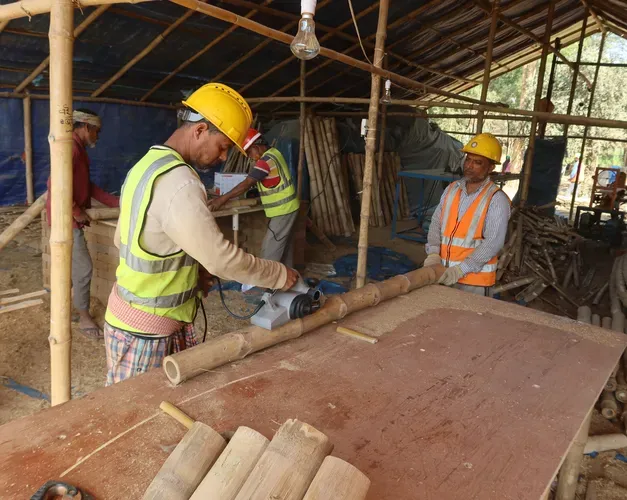 A construction worker prepares bamboo in a workshop