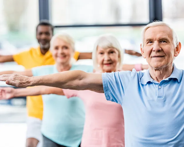 A line of people standing with their arms stretched open at shoulder height