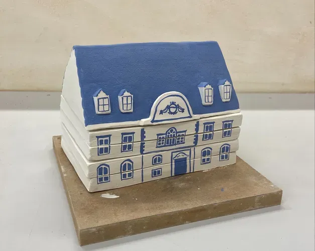 A small model house made of ceramic tiles